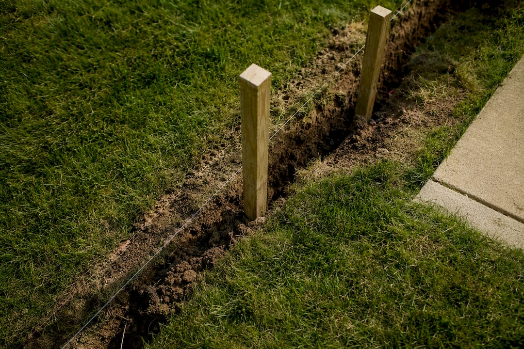 Wood fence posts on property line outdoors