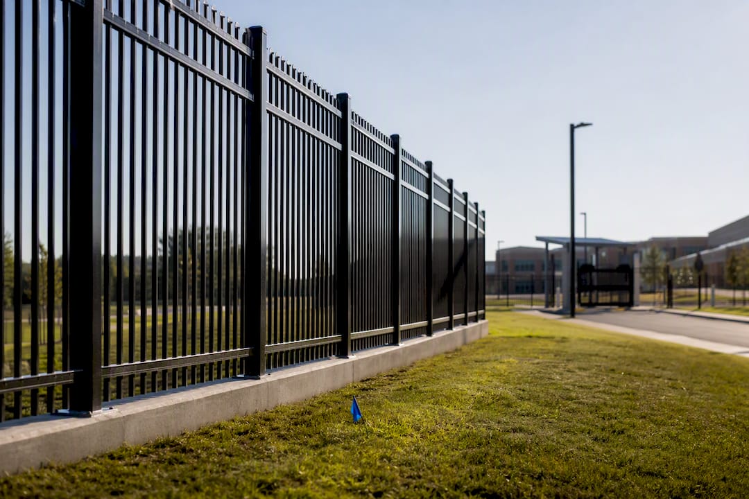 School campus perimeter fence along graded ground