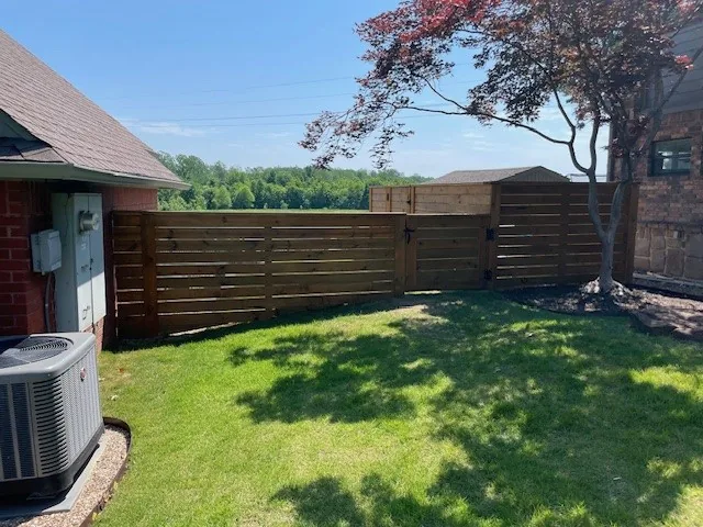 Horizontal wood slat fence enclosing a backyard