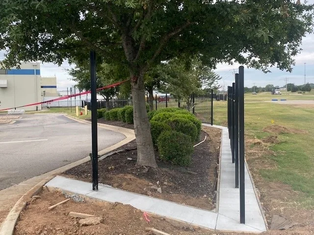 Steel fence posts set in concrete on a commercial site