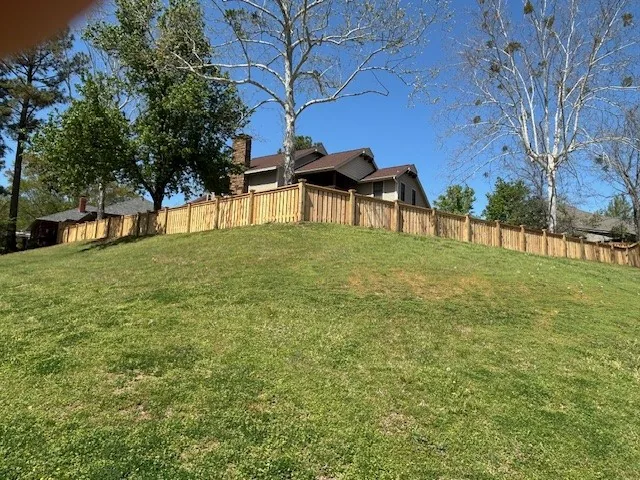 Wood privacy fence stepped to follow a sloped yard