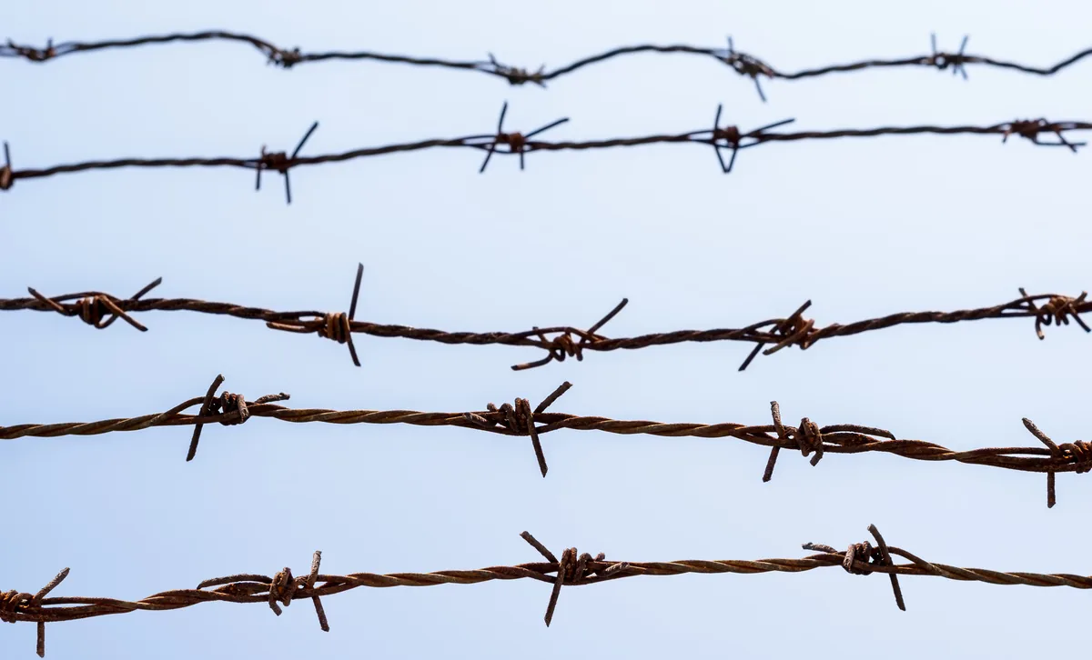 Barbed wire arms on a commercial security fence