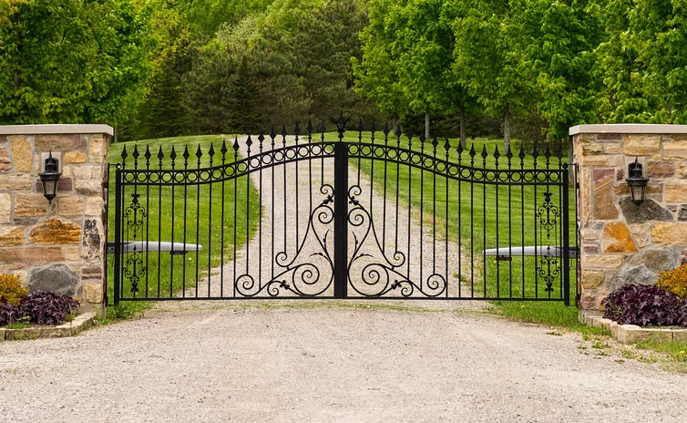 Ornamental iron drive gate hung between masonry columns