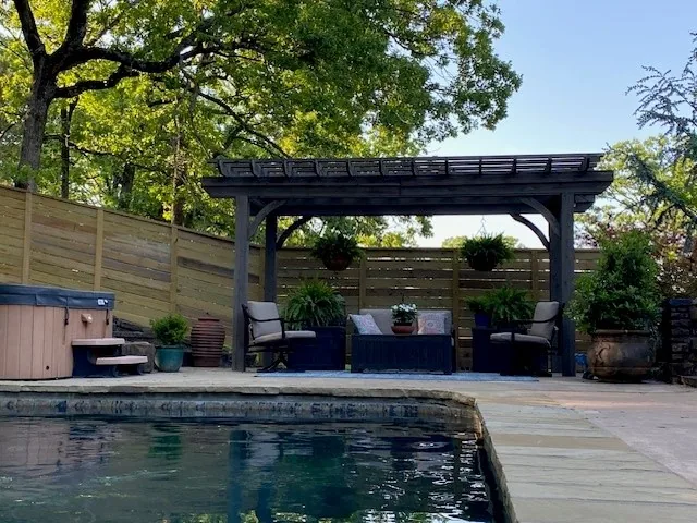 Wood privacy fencing enclosing a pool and pergola area