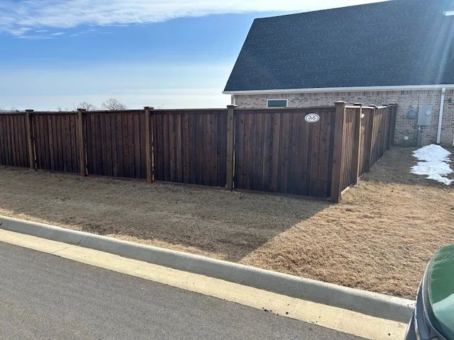 Completed wood privacy fence running along a residential property