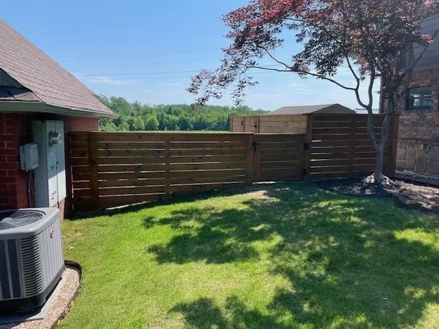 Horizontal wood fence panels along a residential back yard