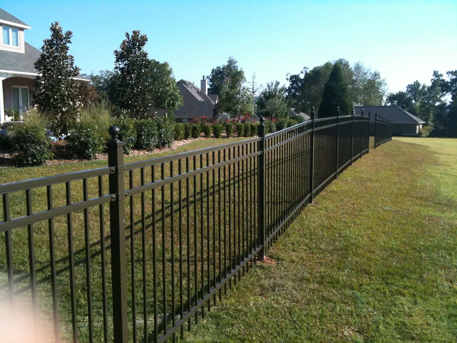 Black ornamental iron fence with ball-cap posts around a residential property