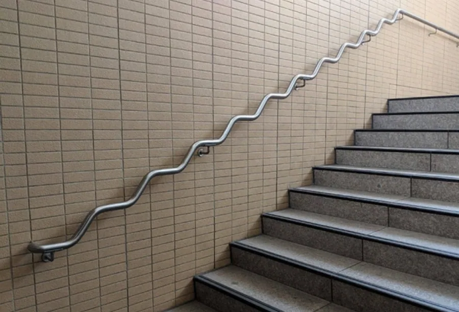 Fabricated metal handrail following an interior stairway