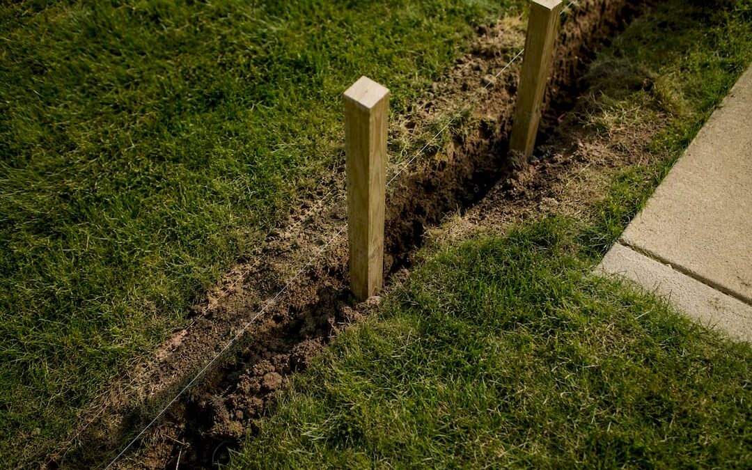 Wood fence posts on property line outdoors