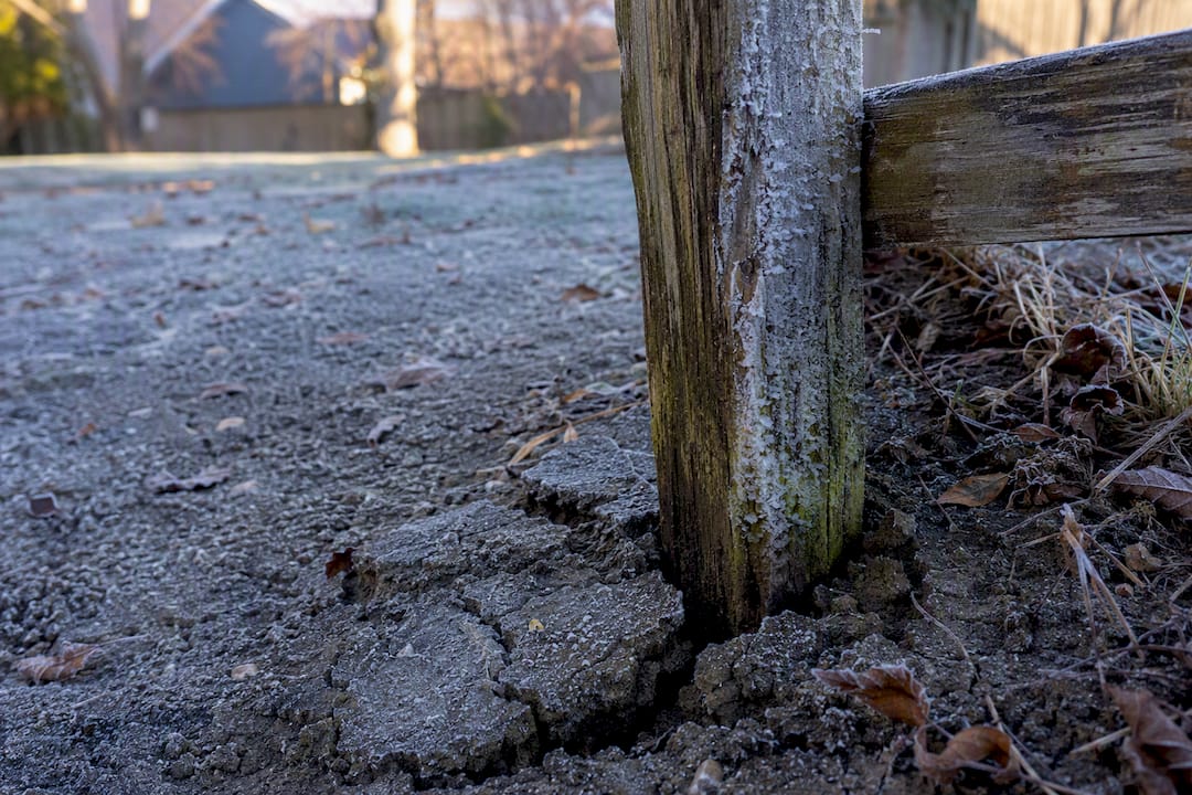 Frost cracking soil near vinyl fence post